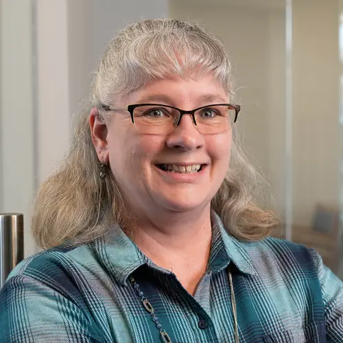 a woman with glasses smiling