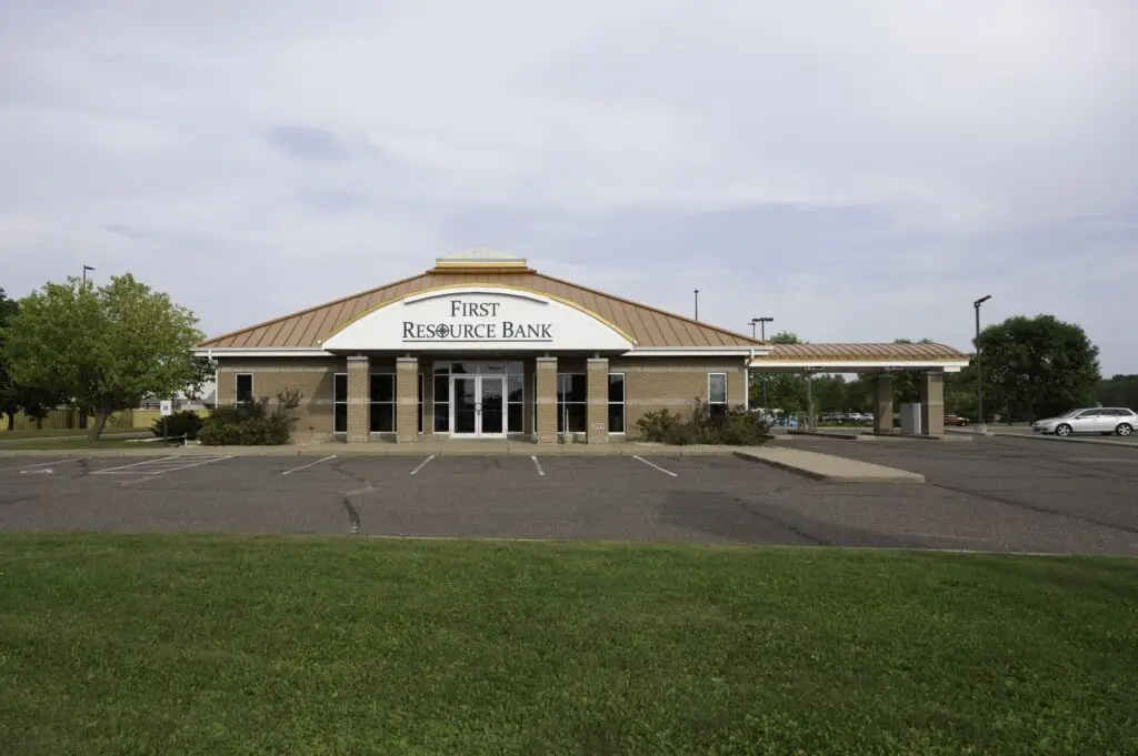 a building with a large parking lot and grass